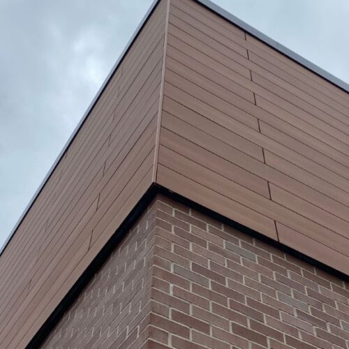 Romantic Walnut and Dark Green Trespa finishes on the Spectrum Facades, showcasing the superior craftsmanship at LL Bean – Tuscan Village